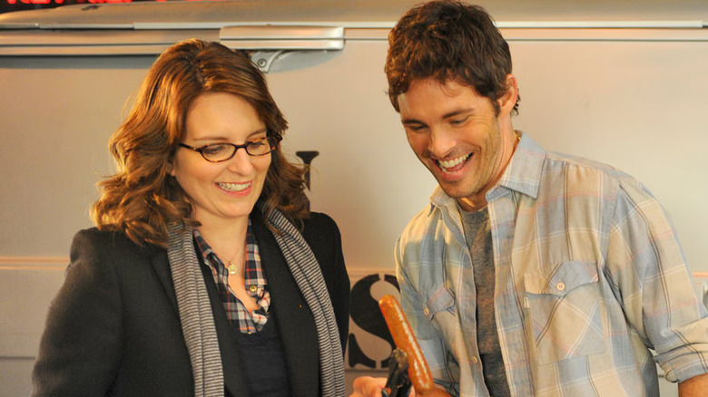 Tina Fey and James Marsden as Liz Lemon and Cris Chros looking at a grilled sausage on 30 Rock