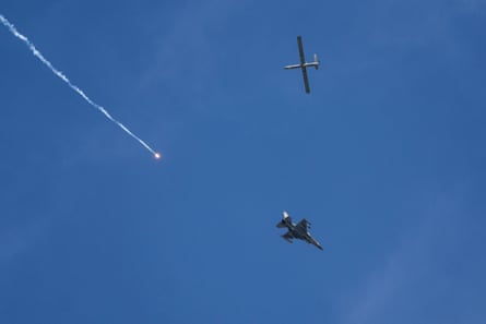 An Israeli fighter jet releases flares, and a drone is seen from Rafah, on 28 May 2024.