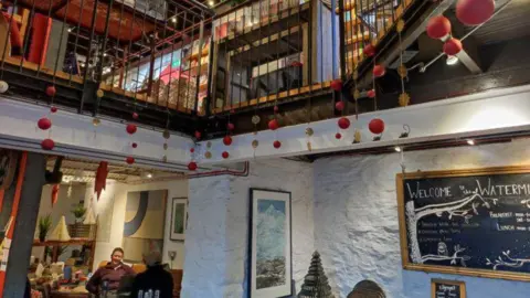 John Argo/The Watermill A busy café is pictured with two floor and decorated with pictures and Christmas bunting. 