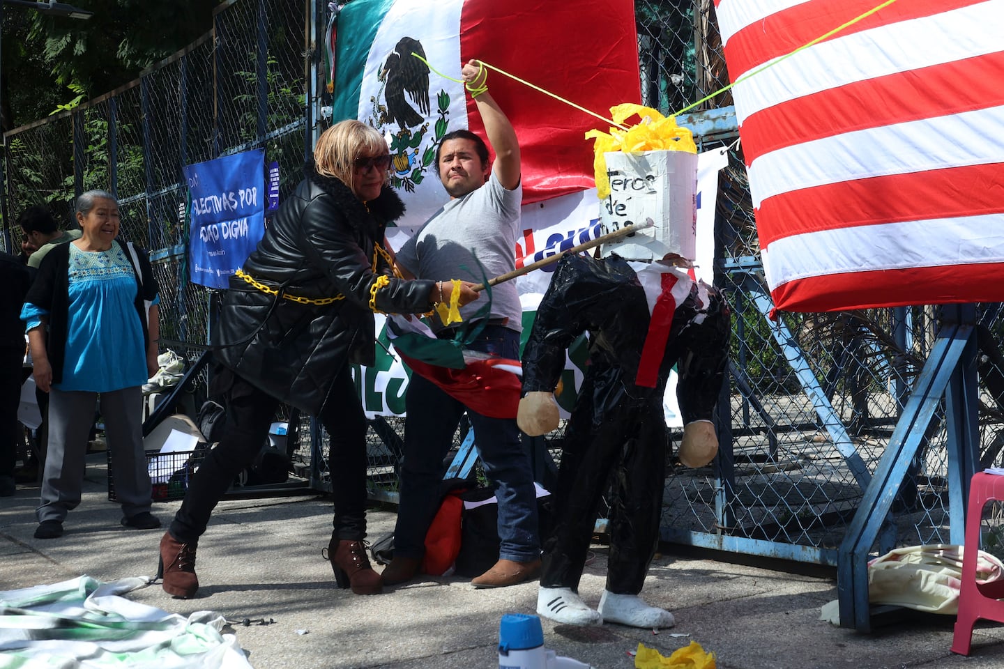 A protester from the Binational Migrant Organization breaks a piñata depicting incoming US President Donald Trump during a protest outside the US embassy in Mexico City on Jan. 20, 2025. 