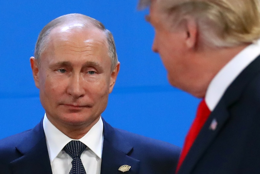 Vladimir Putin stares at Donald Trump with pursed lips.