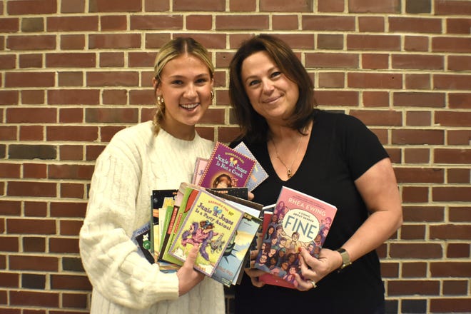 Kohler High School junior Riley Holzrichter, left, and her mom Molly Holzrichter hold several donated books from Kohler Elementary School classrooms for Riley's last biennial book drive, Friday, Jan. 17, 2025, in Kohler, Wis.