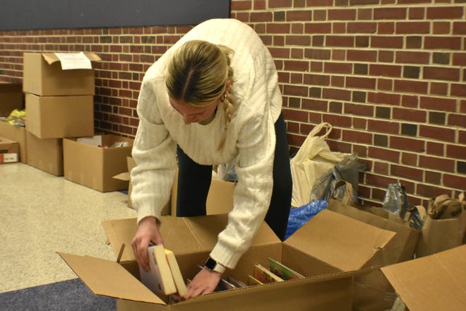 Kohler High School junior Riley Holzrichter sorts books donated by Kohler Elementary School classrooms for her book drive Friday, Jan. 17, 2025, in Kohler, Wis.