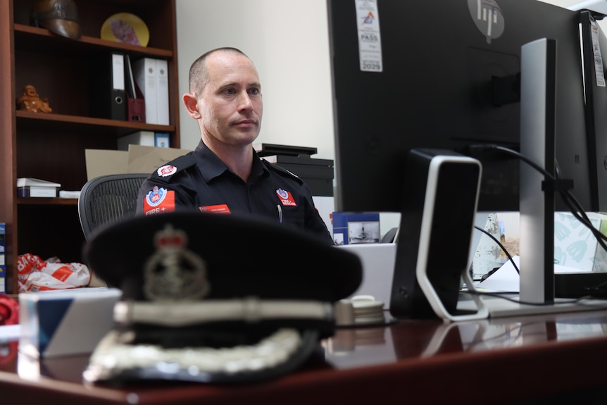 Dr Greg Penney on his desk with his hat