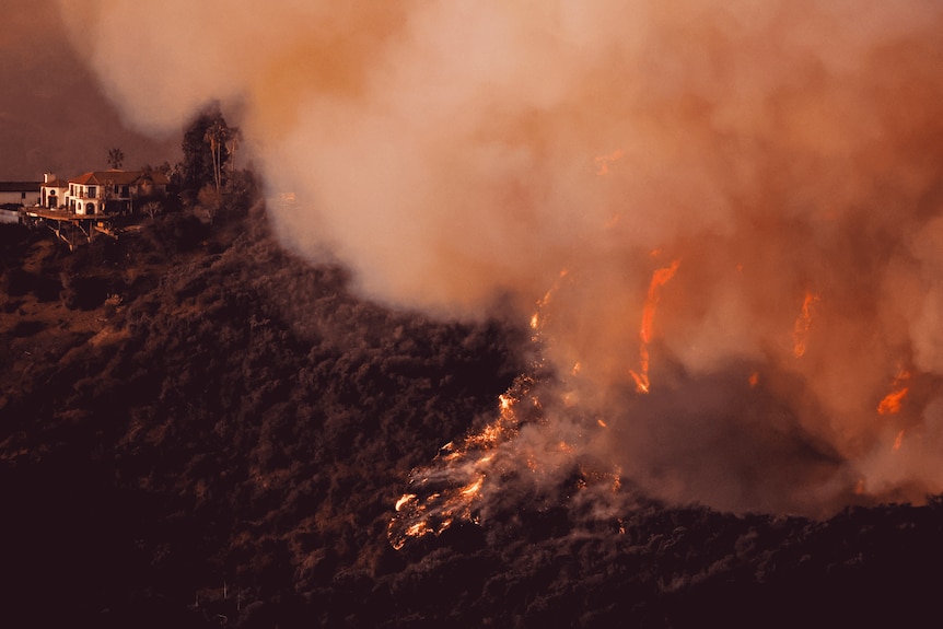 Smoke and fire billow from the Palisades Fire threatening homes in the Brentwood area of Los Angeles