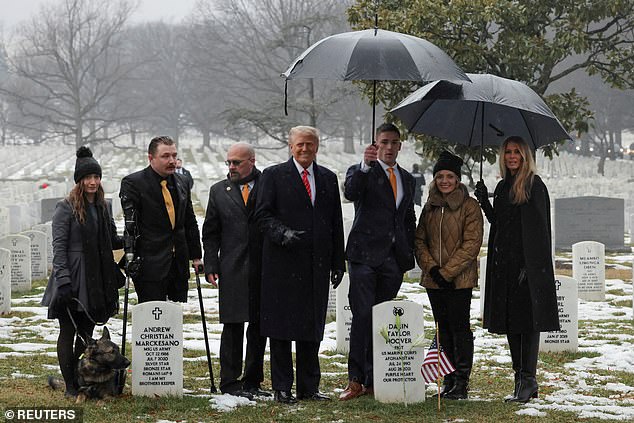 U.S. President-elect Donald Trump and his wife Melania pose with a family of a fallen soldier, Taylor Hoover, as they visit section 60 of Arlington National Cemetery