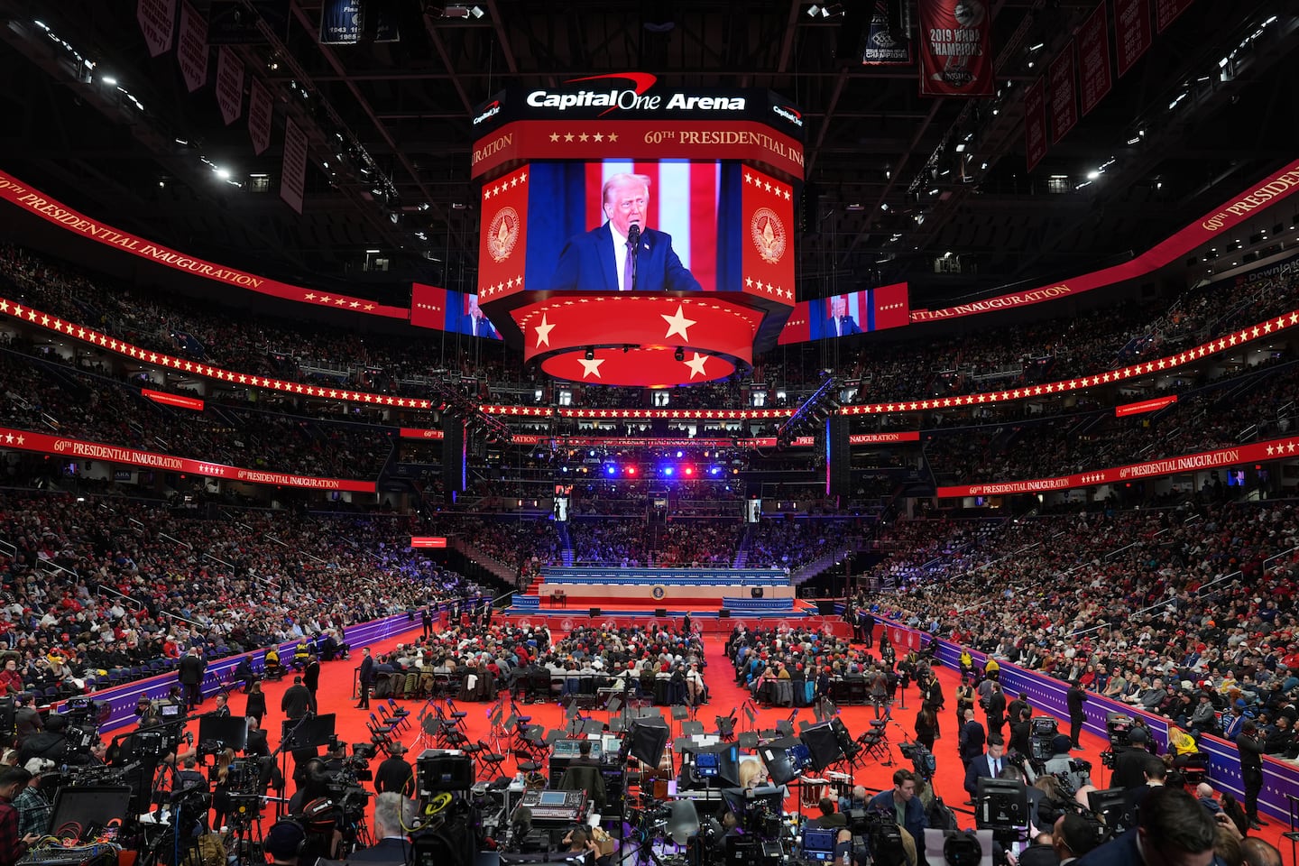 Attendees watch at an Inauguration parade as a screen shows President Donald Trump speaking after taking the oath of office taking the oath of office in Washington, Monday, Jan. 20, 2025.