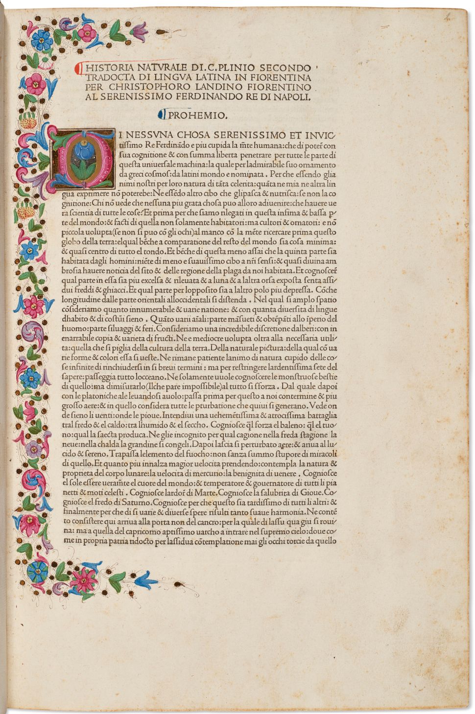 A page from an illuminated manuscript, bordered with colorful floral designs and featuring a decorative initial letter 