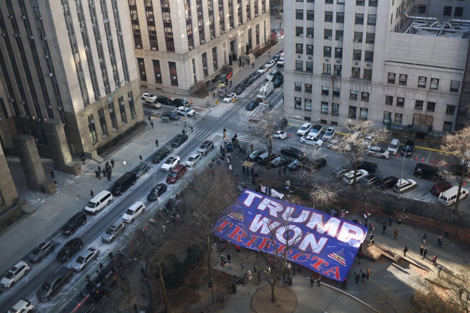 Trump supporters display a giant flag that reads 'Trump Won Trifecta' outside the Manhattan Criminal Court