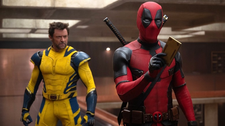 Ryan Reynolds' Deadpool confronting Mr. Paradox at the TV with Hugh Jackman's Wolverine in the background in Deadpool & Wolverine