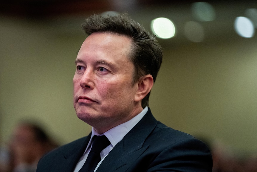 Elon Musk wears a serious expression.