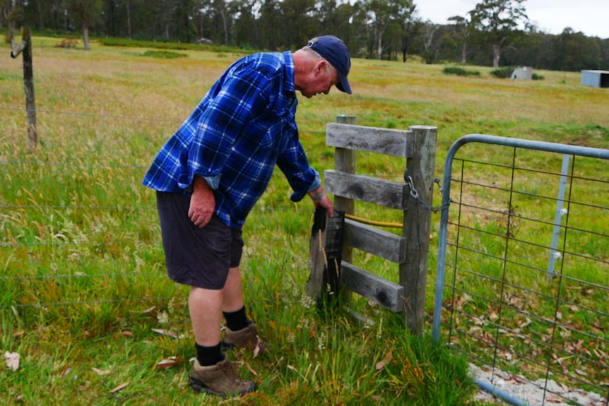 Arick Shoemaker at a fence at the edge of his property