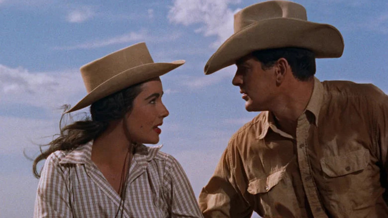 Leslie and Jett face each other while wearing cowboy hats in Giant