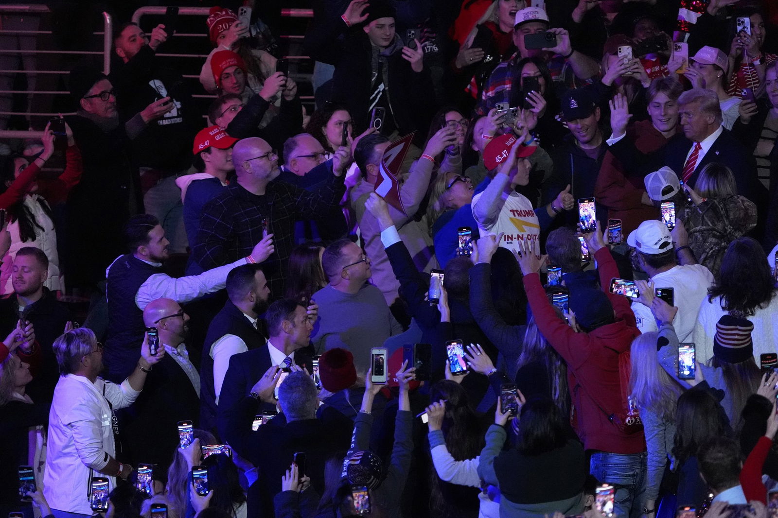 A crowd reaches out as Trump enters the auditorium 