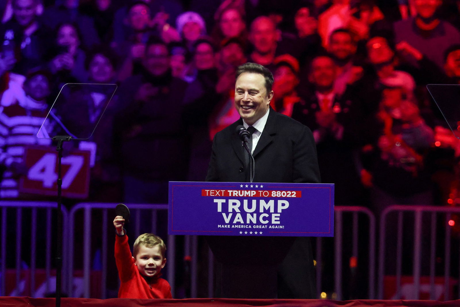 Musk's son raises a fist as Musk smiles