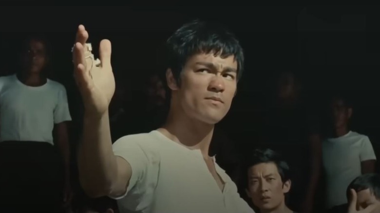 Bruce Lee's Cheng Chao-an raising his arm in The Big Boss