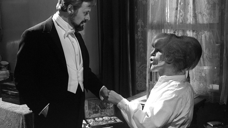 Anthony Hurt as Dr. Frederick Treves chats with John Hurt as John Merrick in The Elephant Man