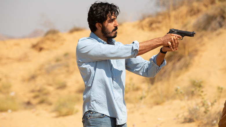 Jay aiming gun in The Wedding Guest