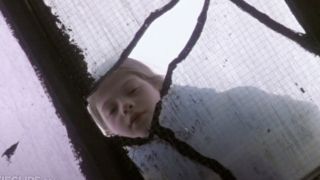 Michelle Trachtenberg as Harriet peering through a window crack in Harriet the Spy