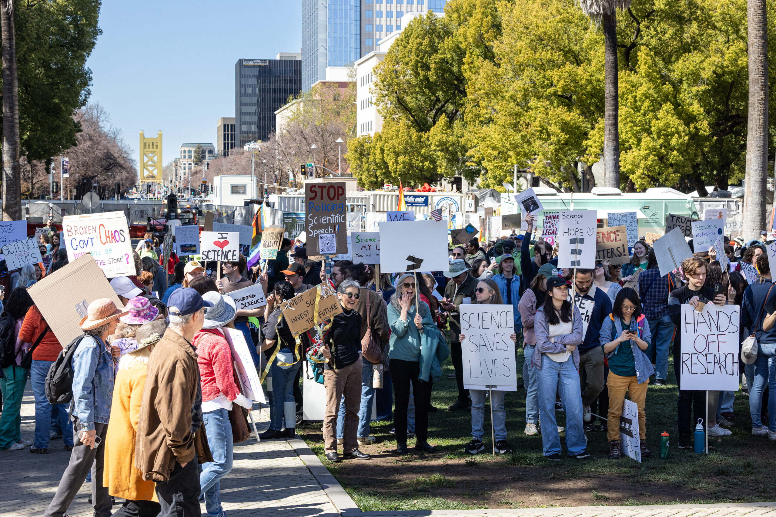 Protesters holding signs advocating for support for scientific researchers