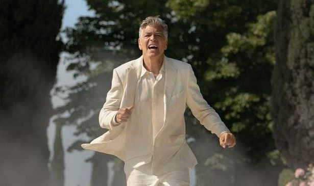 A man in white runs down a road