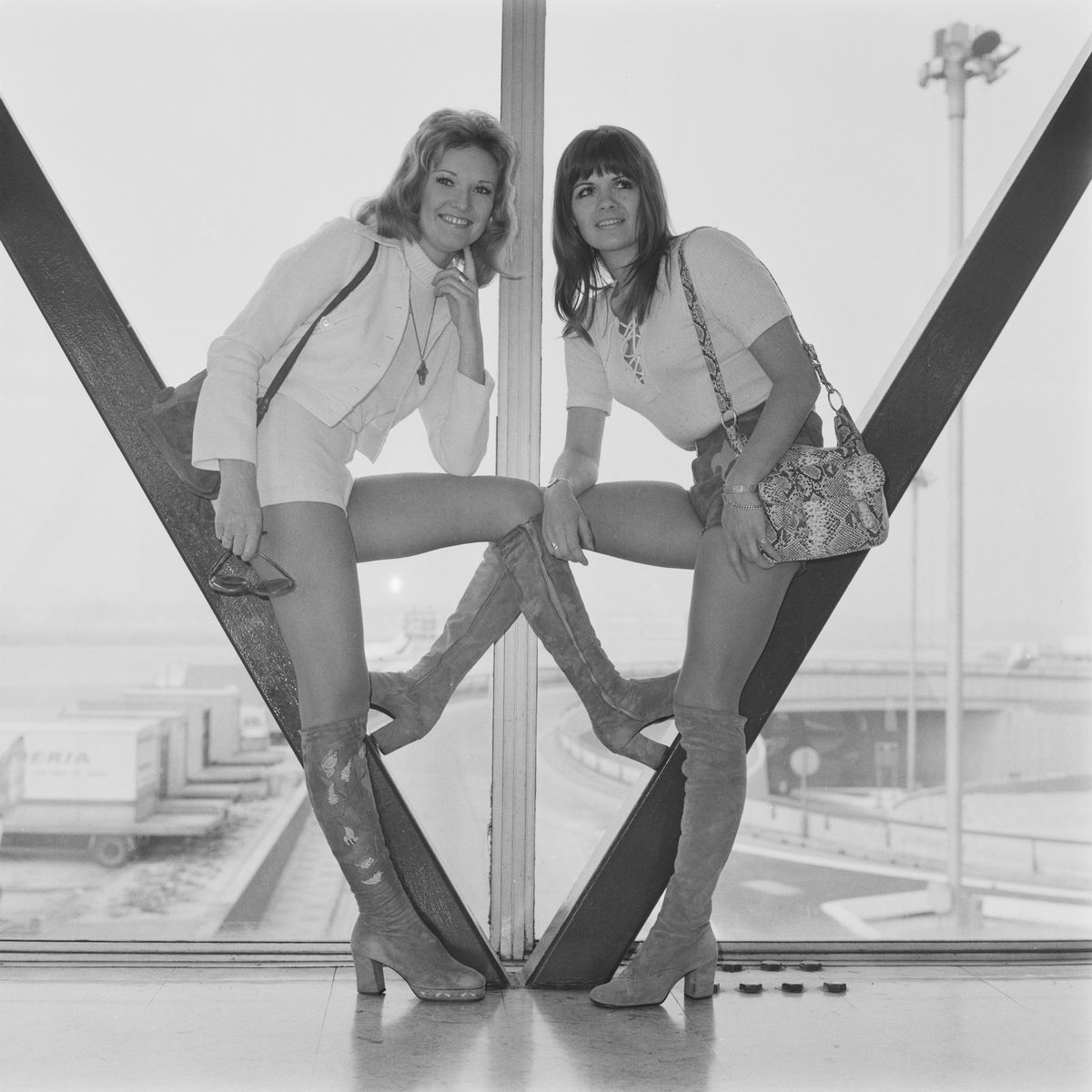 Singers Lyn Paul (left) and Eve Graham of English pop group the New Seekers at London's Heathrow Airport, UK, 1971.   (Photo by Evening Standard/Hulton Archive/Getty Images)