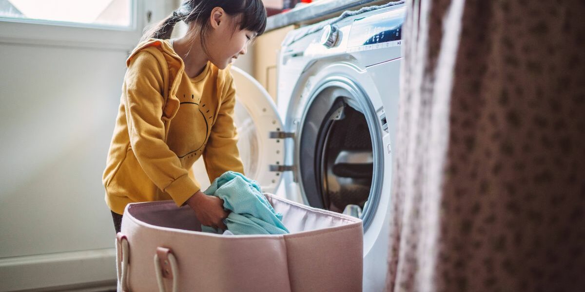 0_Lovely-little-girl-unloading-the-washing-machine-while-helping-her-mom-with-laundry-at-home.jpg
