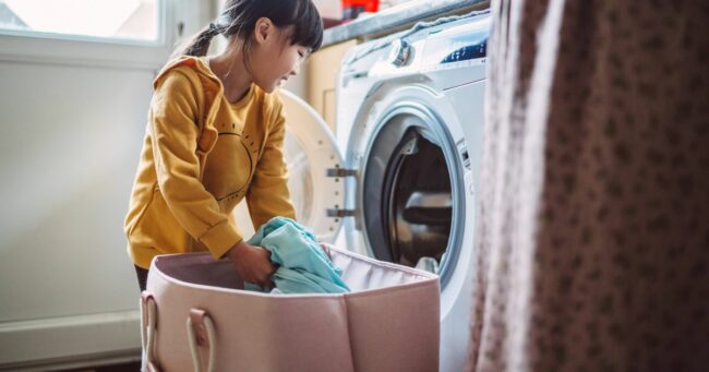 0_Lovely-little-girl-unloading-the-washing-machine-while-helping-her-mom-with-laundry-at-home.jpg