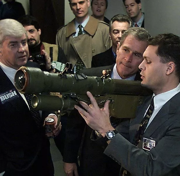 Former Republican vice presidential candidate Jack Kemp (L) and GOP presidential hopeful Texas Governor George W. Bush (C) inspect a Soviet-built shoulder mounted missile launcher while touring Lockheed Sanders 27 January 2000 in Nashua, New Hampshire.    (ELECTRONIC IMAGE) AFP PHOTO/Paul J. RICHARDS (Photo by PAUL J. RICHARDS / AFP) (Photo by PAUL J. RICHARDS/AFP via Getty Images)