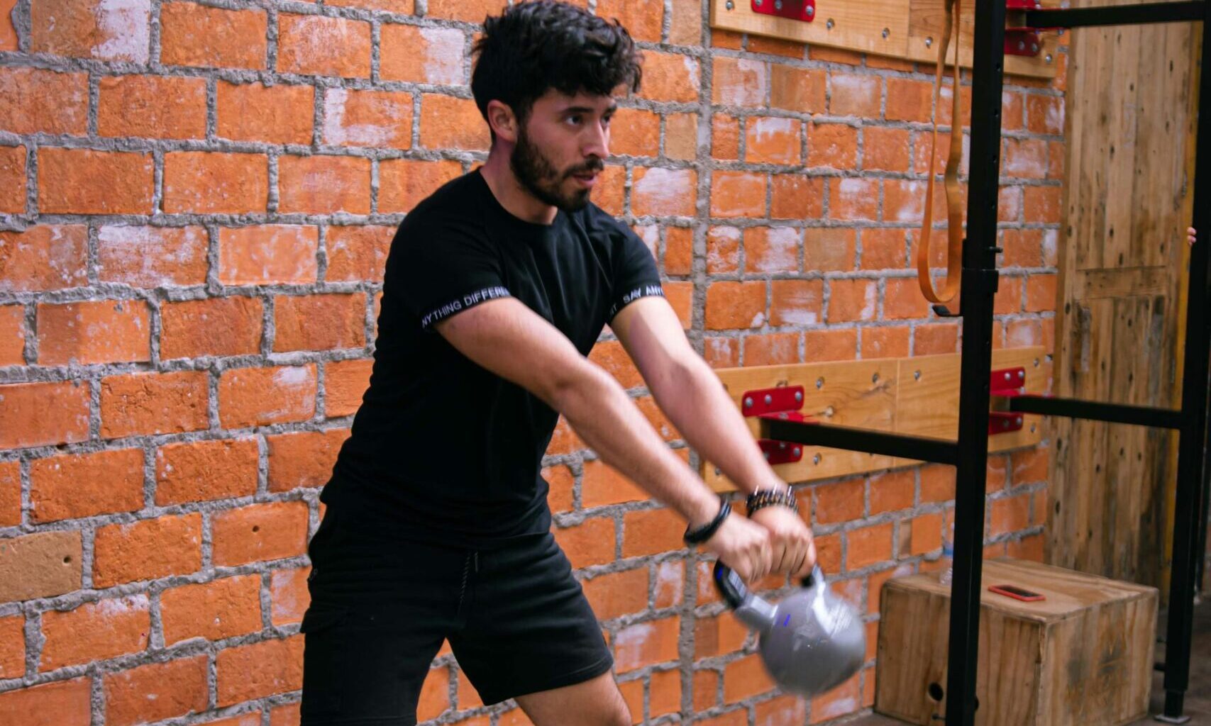 man kettlebell swing in gym