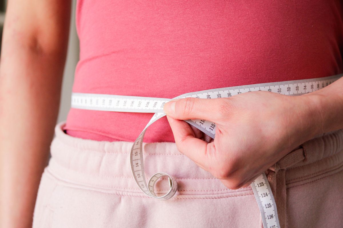 Woman measuring waist with tape