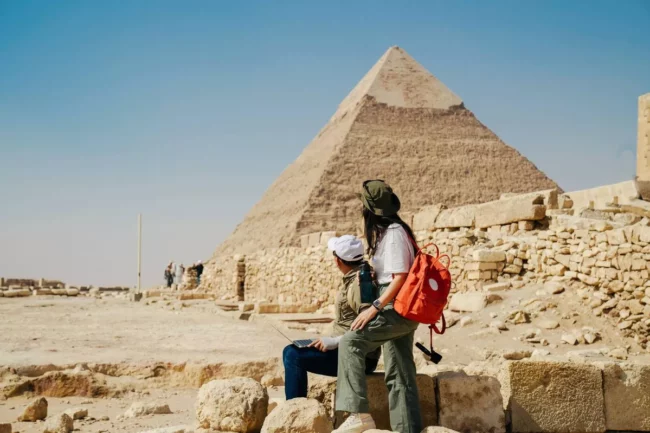 1_Multiracial-couple-working-on-their-laptops-in-giza-area-pyramid-pharaoh-Cairo.jpg