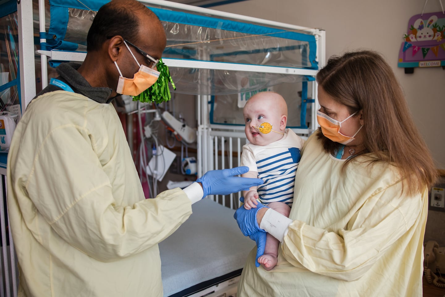 Cardiologist Kiran Musunuru and pediatric geneticist Rebecca Ahrens-Nicklas hold KJ Muldoon after he received an infusion of a drug custom-made for him.