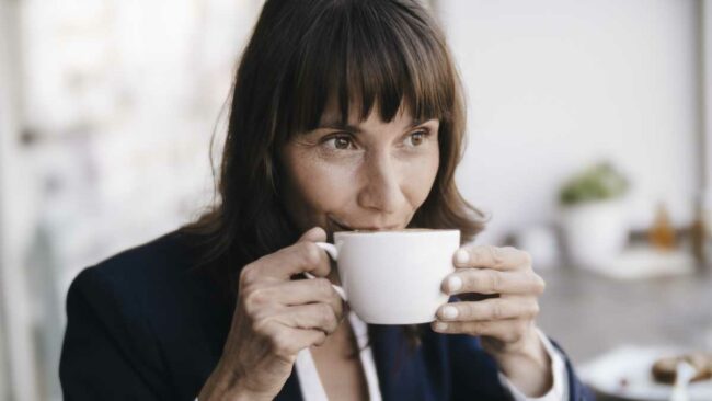 businesswoman-sitting-in-cafe-drinking-coffee-royalty-free-image-1766178583.pjpeg