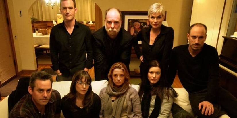 The cast of Coherence (2013) gather on a couch in a house.