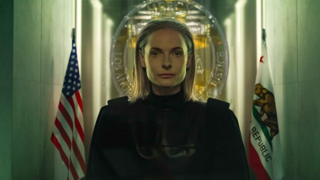 judge-maddox-rebecca-ferguson-sitting-stoically-between-two-flags-in-mercy.jpg