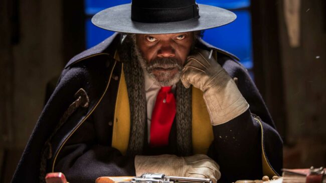 samuel-l-jackson-s-warren-looking-intensely-toward-the-camera-while-sitting-a-table-with-a-revolver-in-front-of-him-in-the-hateful-eight.jpg