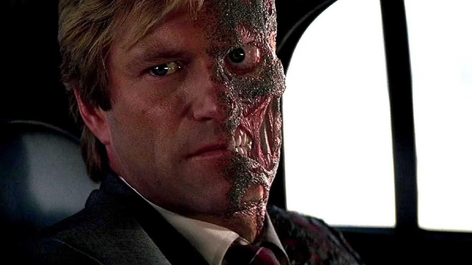 Aaron Eckhart's Harvey Two-Face rides a car in The Dark Knight