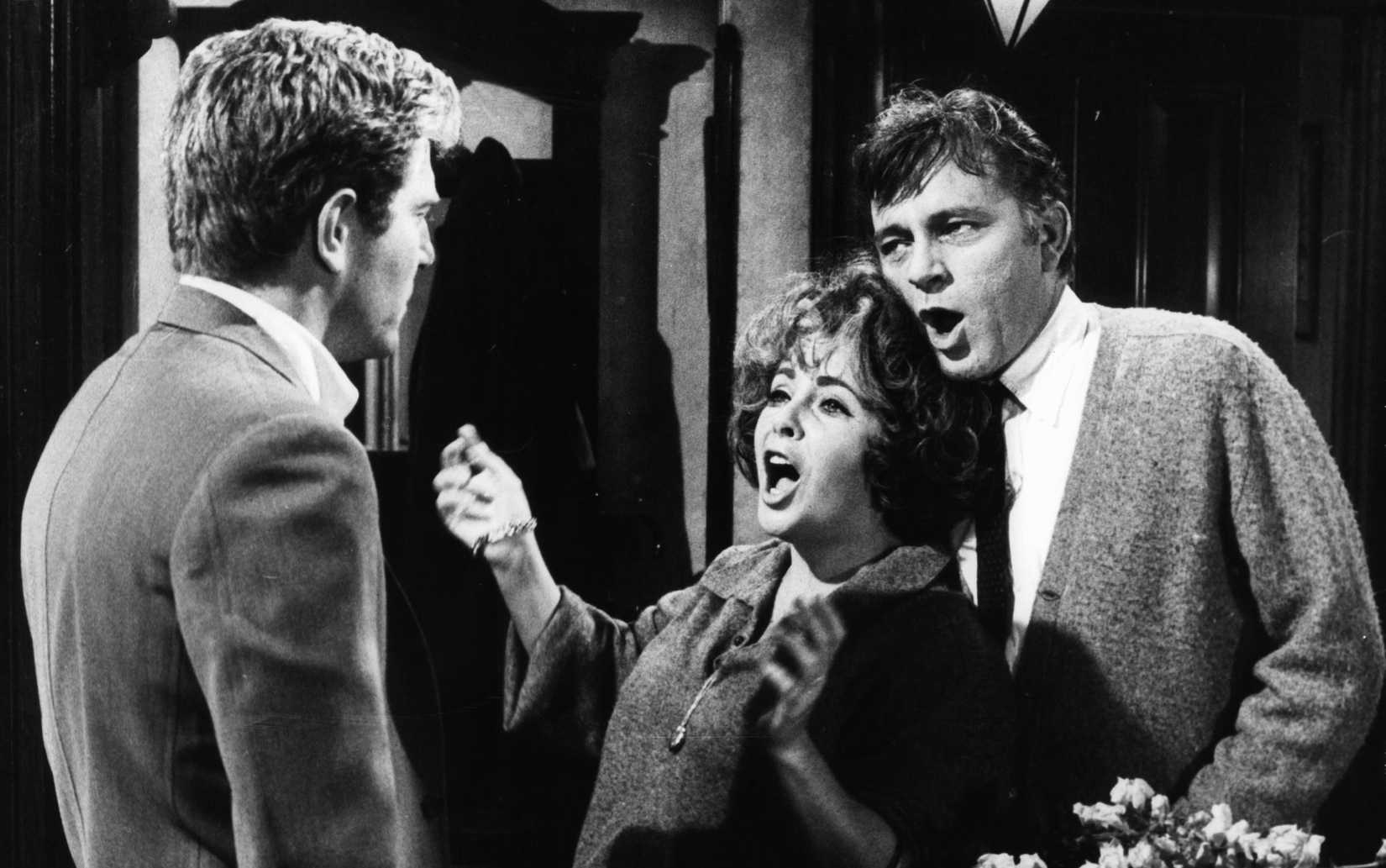 Richard Burton and Elizabeth Taylor aggressively sing at a man with his back to the camera in Who's Afraid of Virginia Woolf