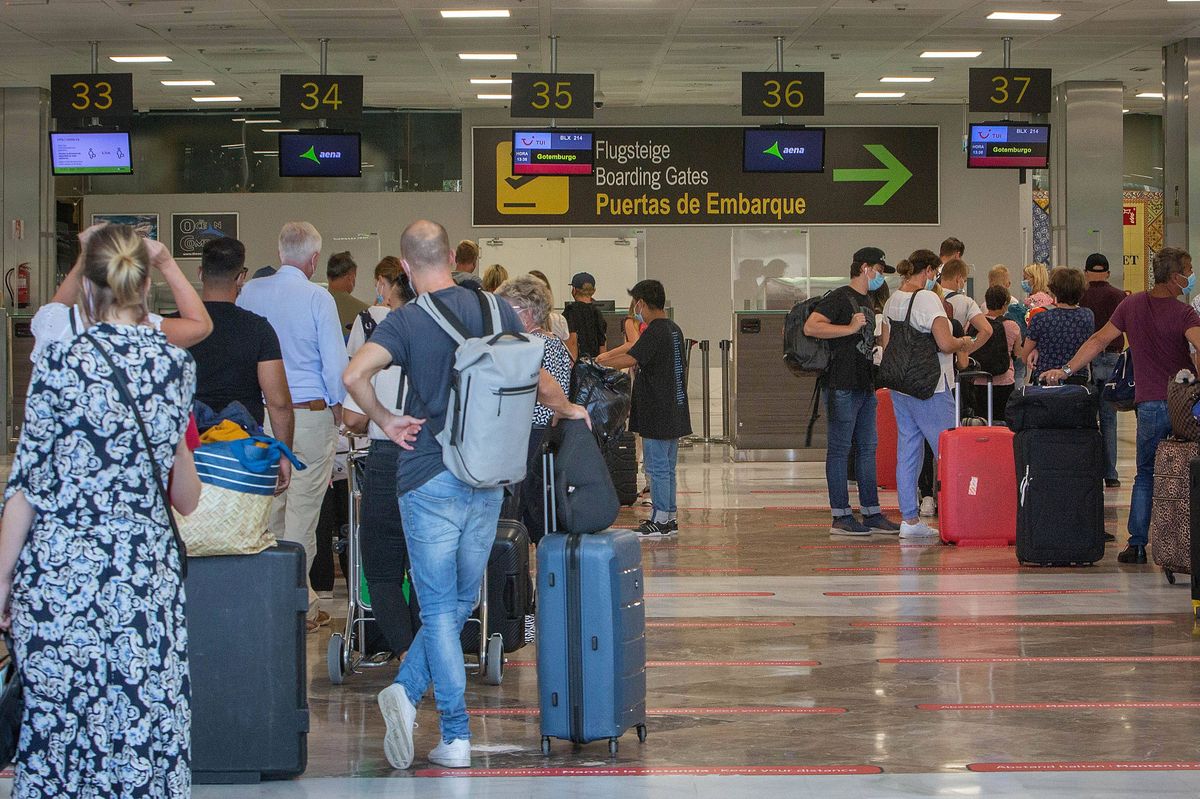 Tourists queue on their way to their boarding gates at the Reina Sofia Tenerife-South airport on the Canary Island of Tenerife on October 31, 2020. - Spain has declared a national state of emergency and a curfew covering all of Spain except the Canary Islands where infections are lower. (Photo by DESIREE MARTIN / AFP) (Photo by DESIREE MARTIN/AFP via Getty Images)