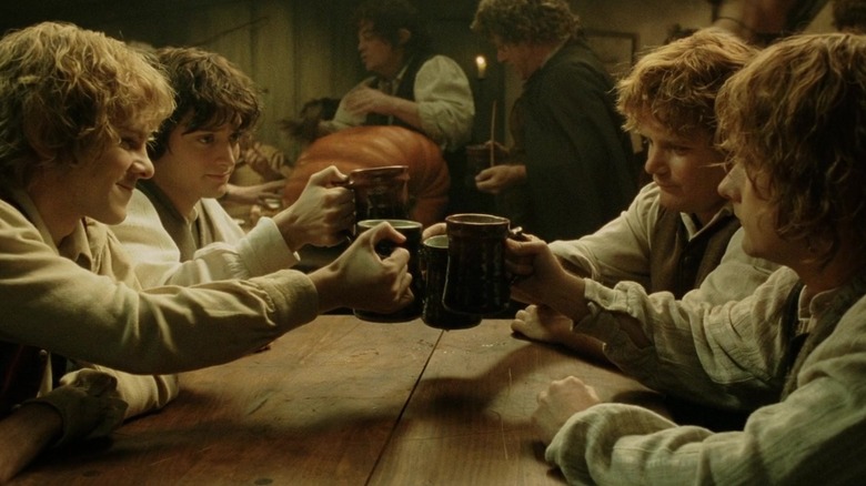 Frodo, Sam, Pippin, and Merry share a toast back in the Shire after going through hell in The Lord of the Rings: The Return of the King