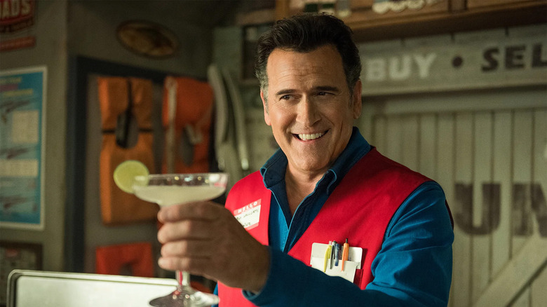 Bruce Campbell as Ash Williams in Ash vs the Evil Dead holding up a cocktail