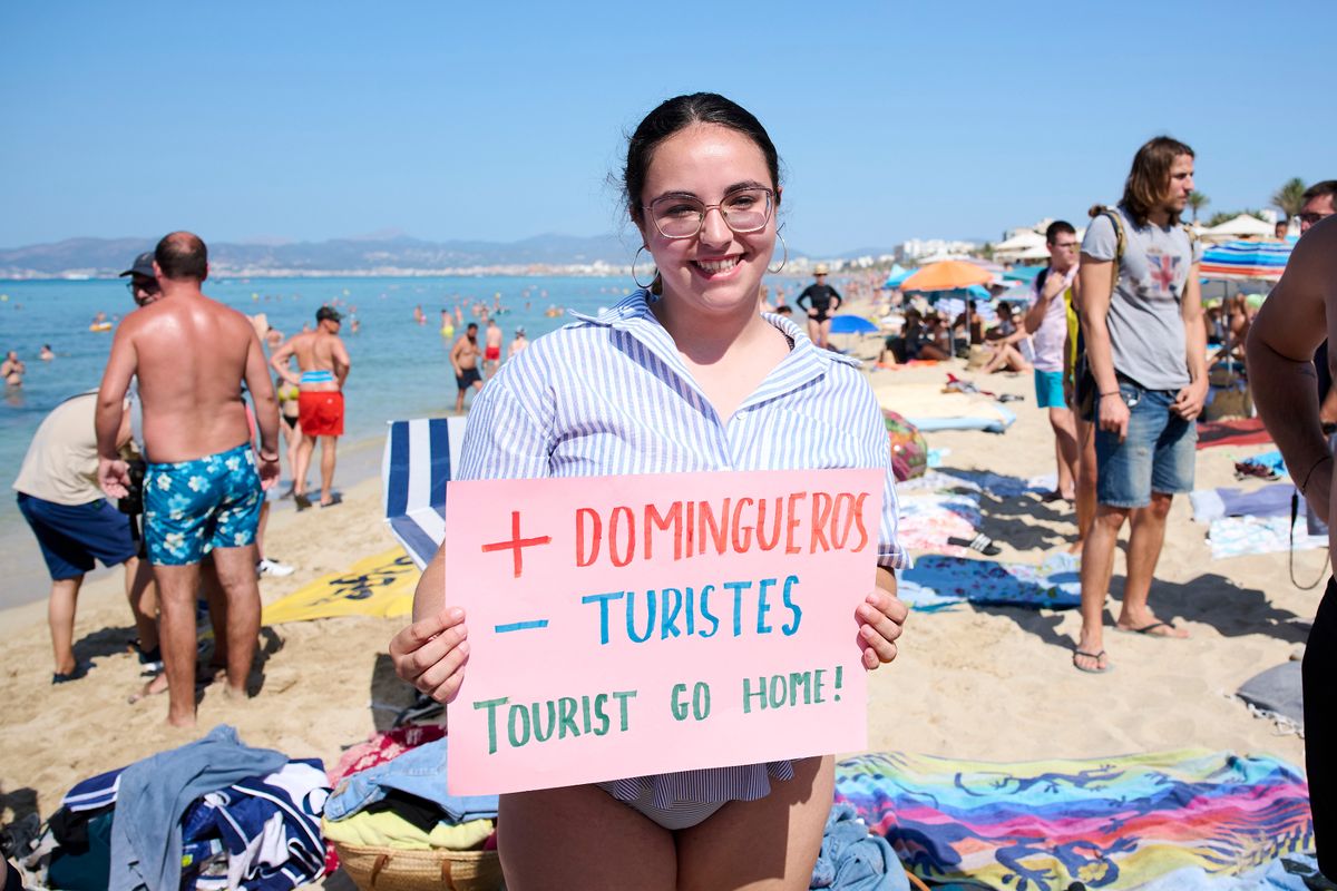 A member of the Mallorca Platja Tour association demonstrates against the tourist saturation on the beach of Palma de Mallorca