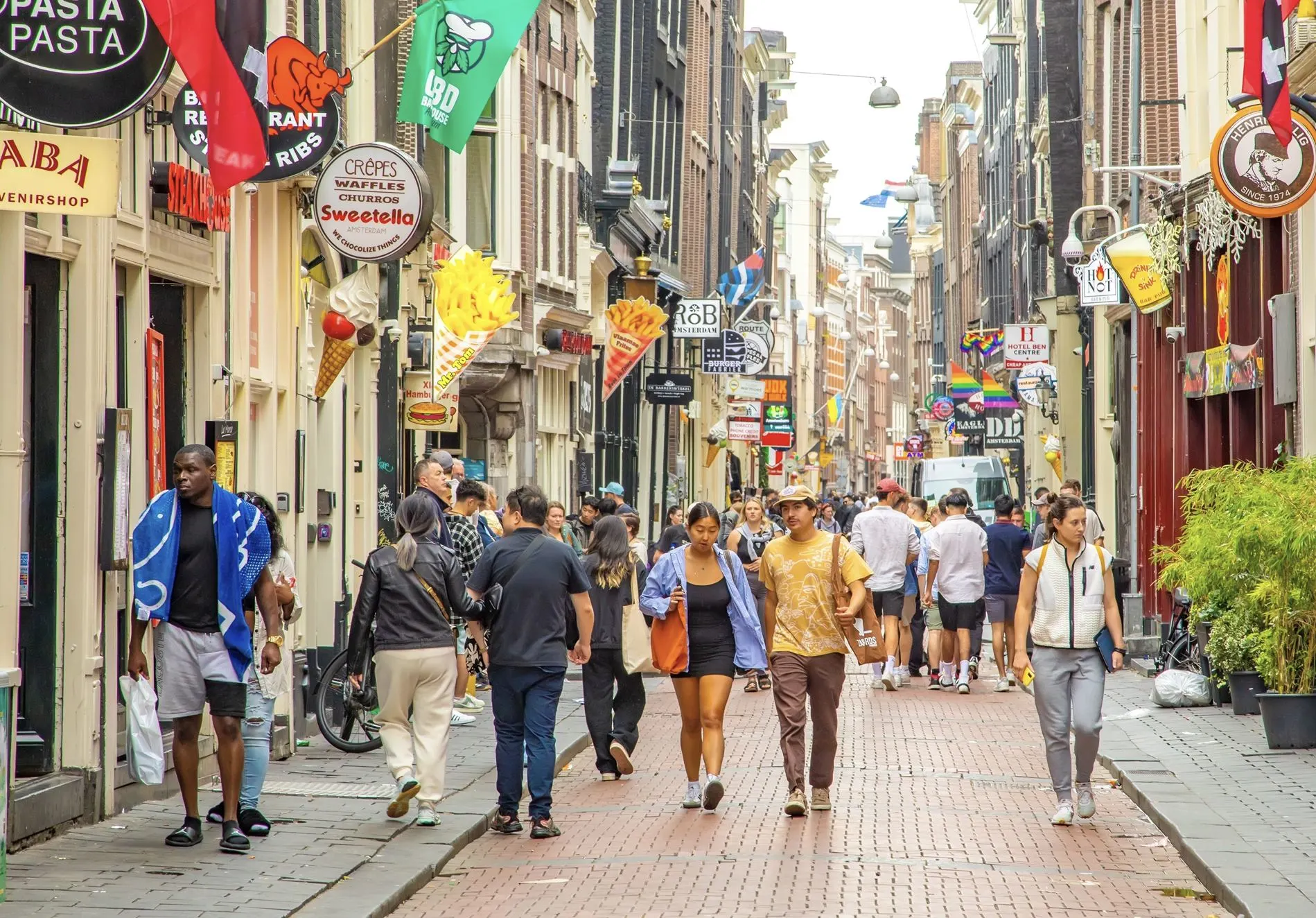 Many Travelers Walking and enjoying street of Amsterdam