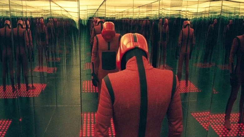 Strange red suited figure with a red helmet and full face mask in a mirrored room in Beyond the Black Rainbow