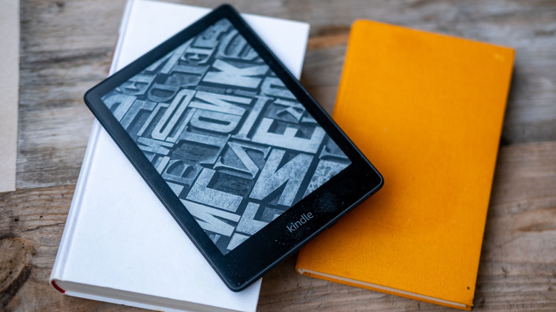 A Kindle kept on two white and yellow books