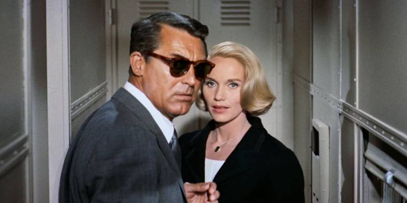 Cary Grant and Eve Marie Saint as Roger and Eve in a train aisle, staring towards the camera