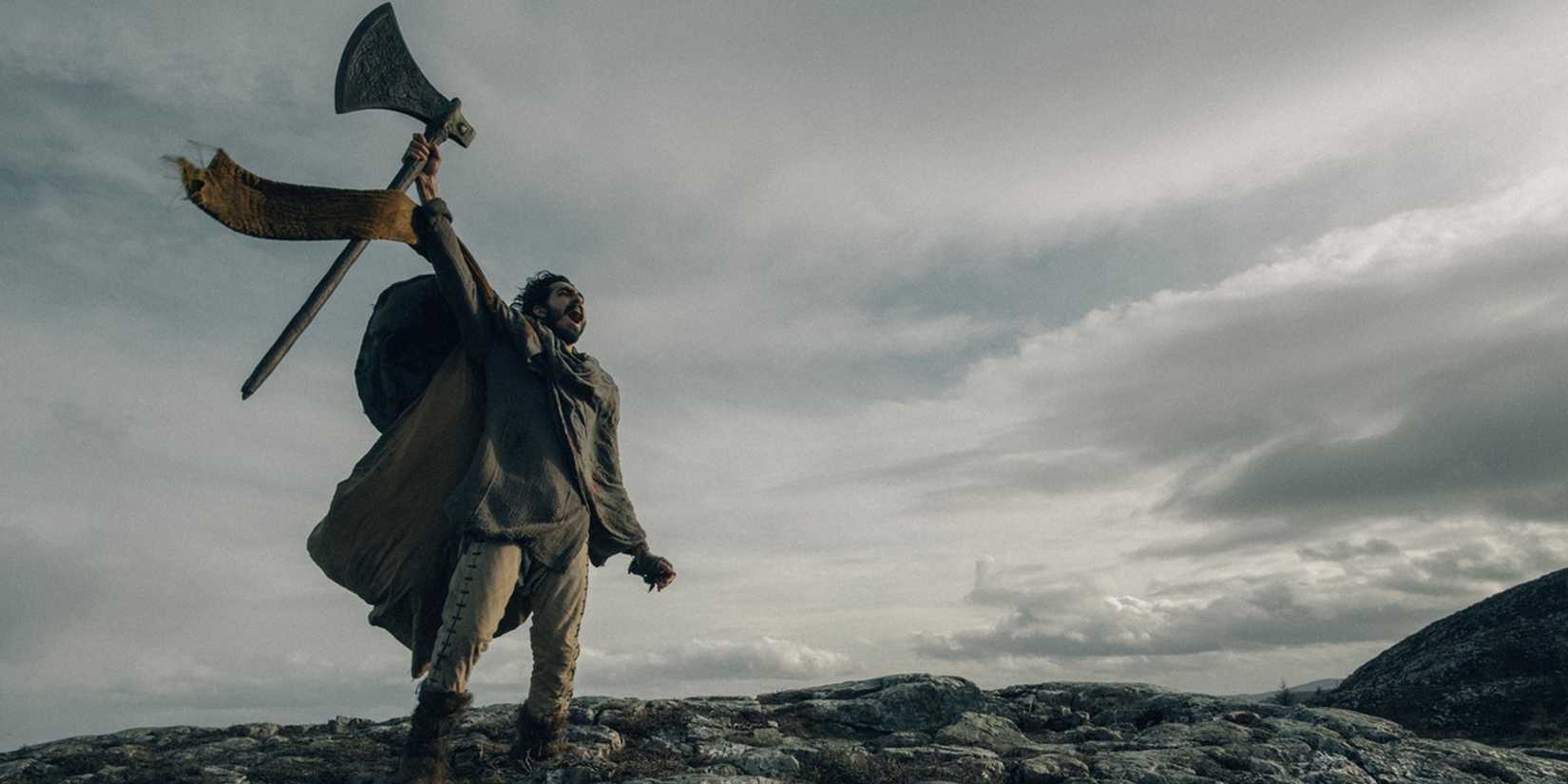 Dev Patel raising his axe in 'The Green Knight'