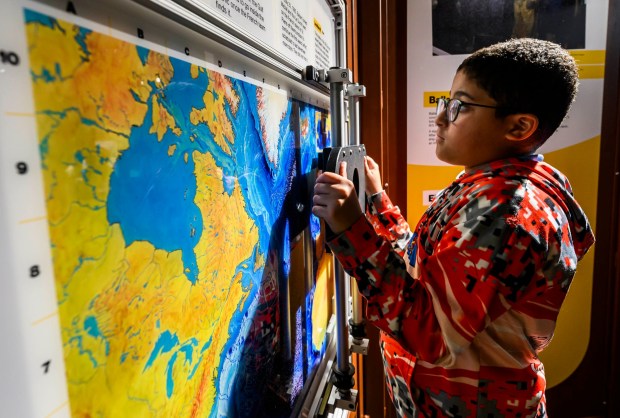 Allentown School District fifth grader Zabdiel looks at maps in the 