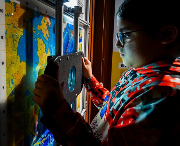 Allentown School District fifth grader Zabdiel looks at maps in the 